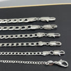Set of silver chain necklaces on a dark surface