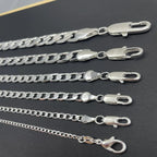 Set of silver chains with clasp on a dark surface