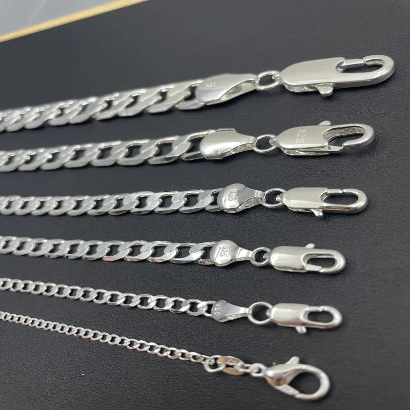Set of silver chains with clasp on a dark surface
