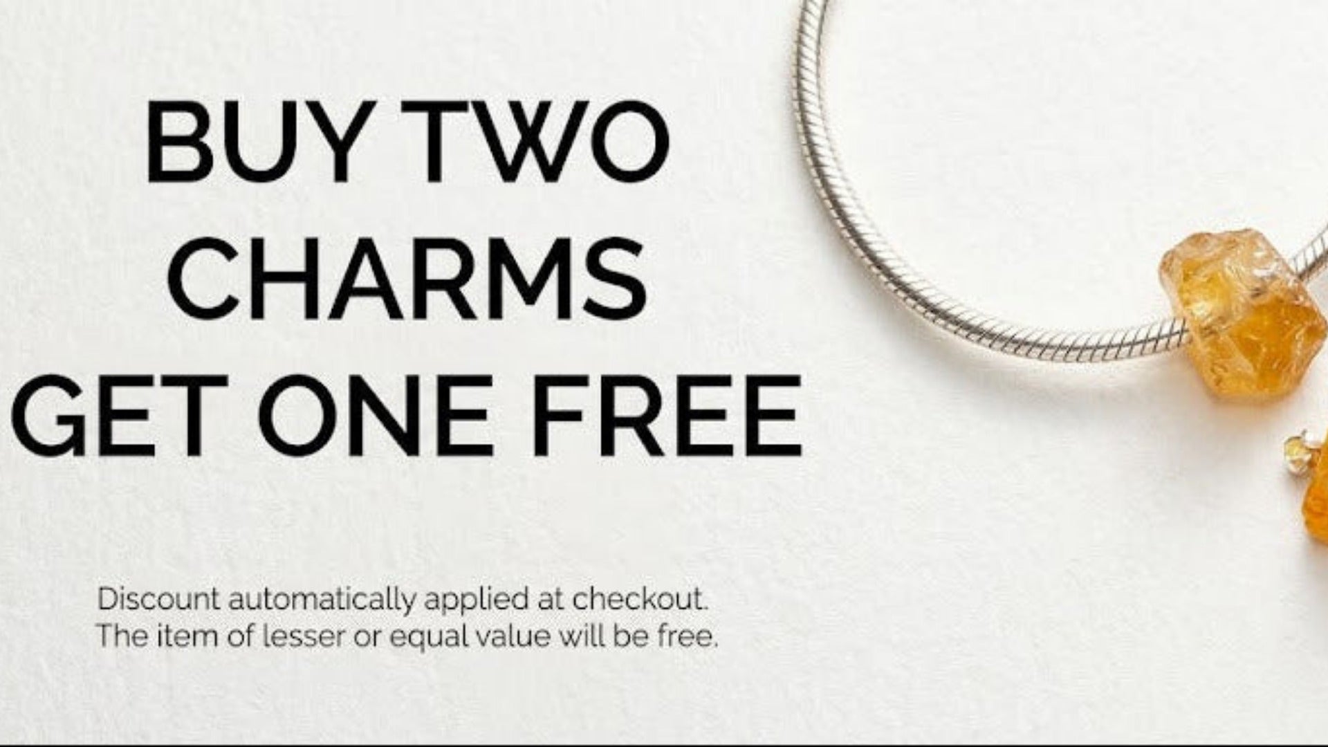 Promotional banner for jewelry charms featuring several rough, faceted amber-orange stone charms and a silver-toned wire hoop on a white background, with text reading 'BUY TWO CHARMS GET ONE FREE'.
